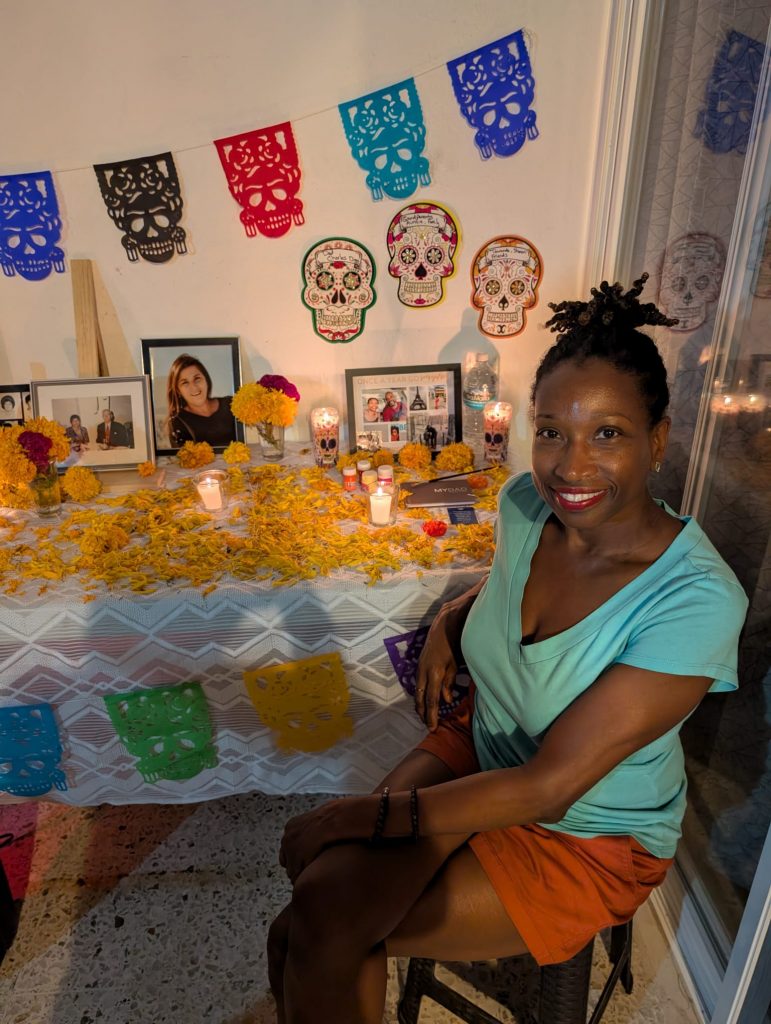 Student poses in front of a Day of the Dead decorative altar in Cuernavaca