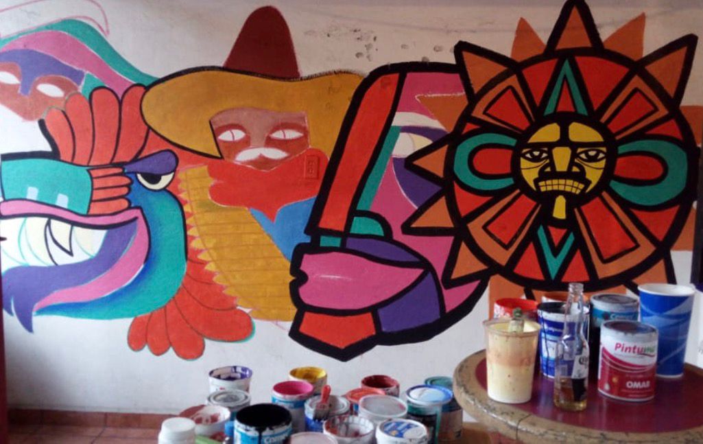 Mexican Aztec-inspired street art wall painting in Malinalco Mexico, showing the aztec calendar and the Aztec god Quetzalcoatl