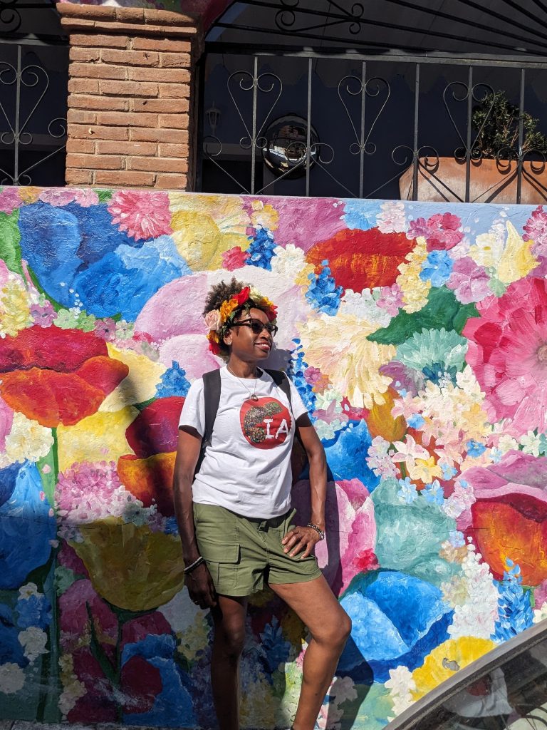 Woman posing in front of a wall of colorful street art in Malinalco Mexico