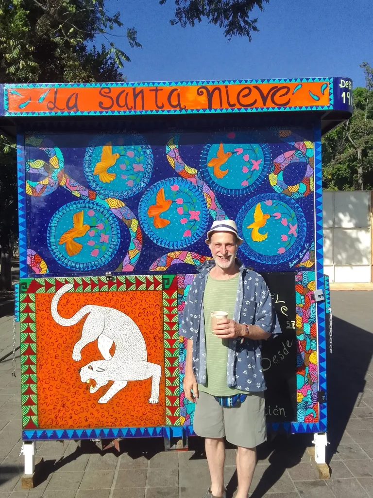 Retired American in Mexico, posing in front of colorful art