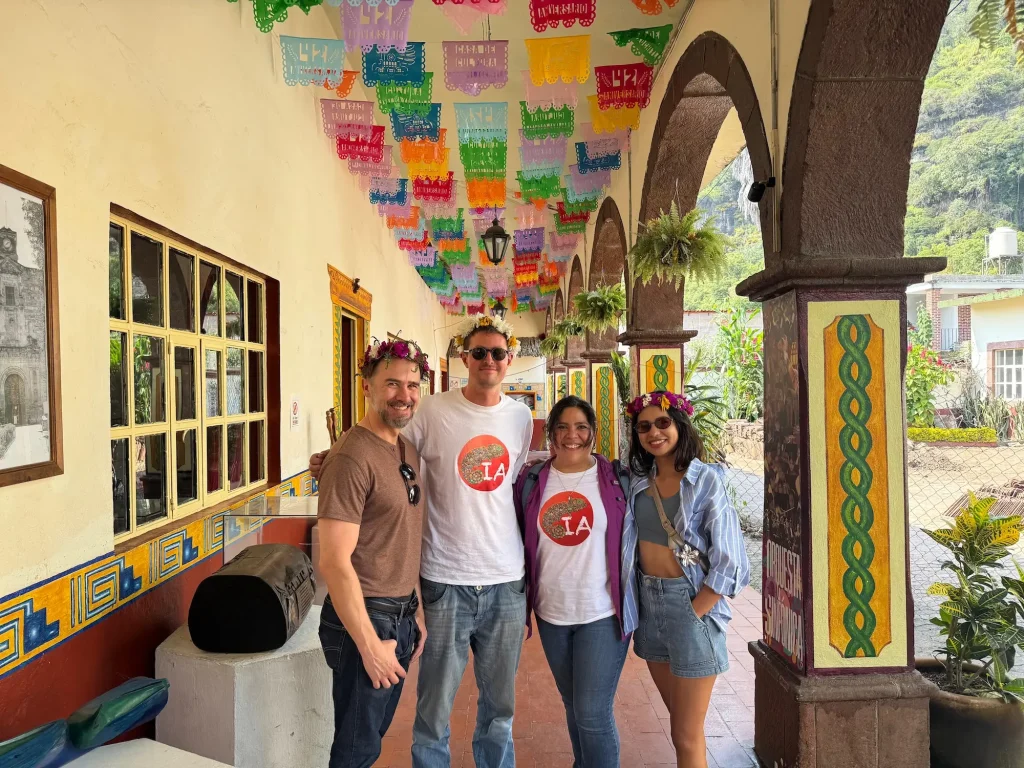 Group of 4 Spanish immersion students posing inside a historical building in Malinalco under some papel picado bunting